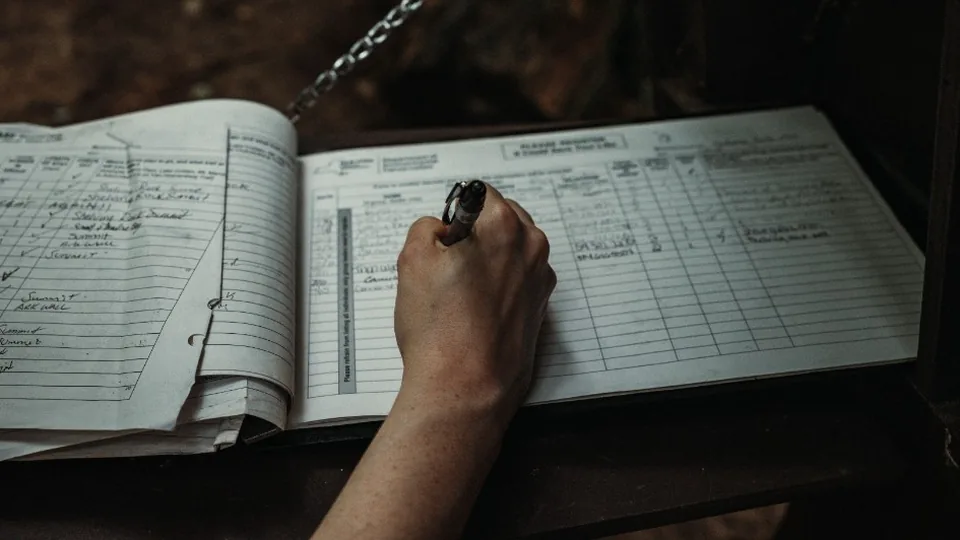 Hand writing entries in a logbook
